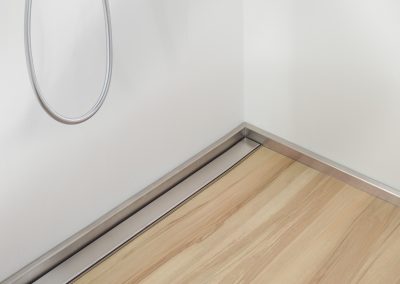 Shower floor element with channel drain and side panel